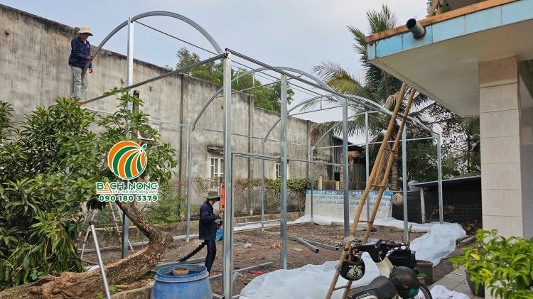 Công nhân của Bách Nông đăng lắp đặt phần khung nhà màng trồng rau mini cho khách